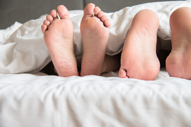 The feet of two people sticking out from covers